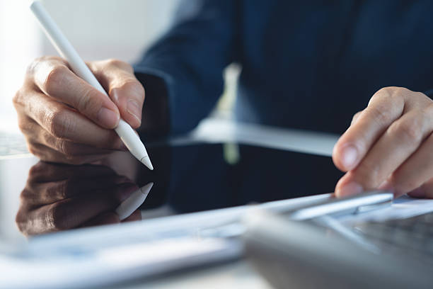 istock Close up, business woman using stylus pen signing digital document on digital tablet during working on laptop computer on office table. E-signing, electronic signature, business technology 2250640543