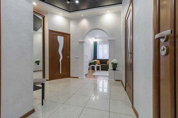 Bright hallway interior with archway leading into a cozy living room with soft lighting.