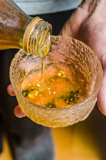 Pouring Golden Honey Into a Glass Bowl