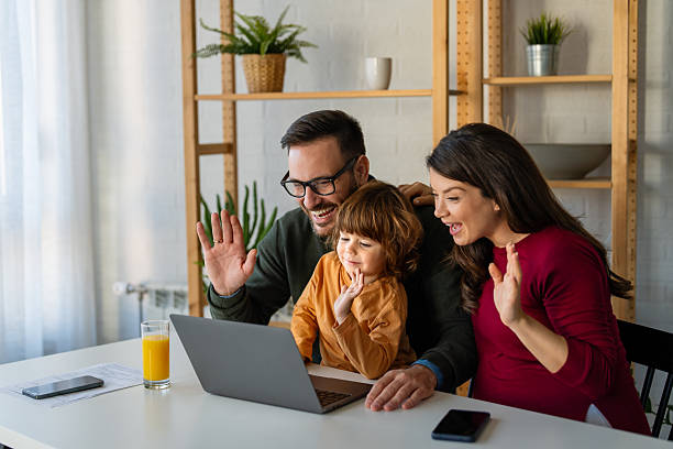 istock Parents and child relaxing at home with computer watching funny internet video, making online call 2250650037