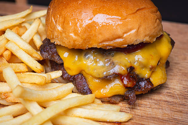 istock Double cheeseburger with fries on wooden board. 2250650566