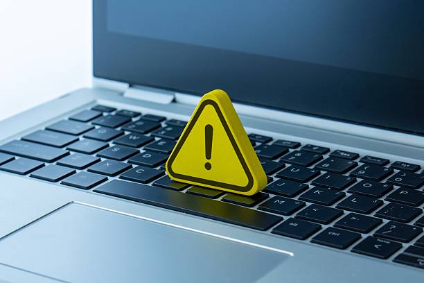 istock A yellow warning sign with an exclamation mark placed on a laptop. 2250652173