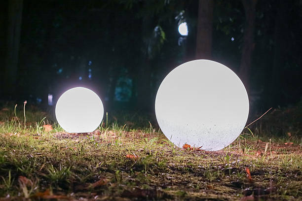 Illuminating garden lamp on green lawn