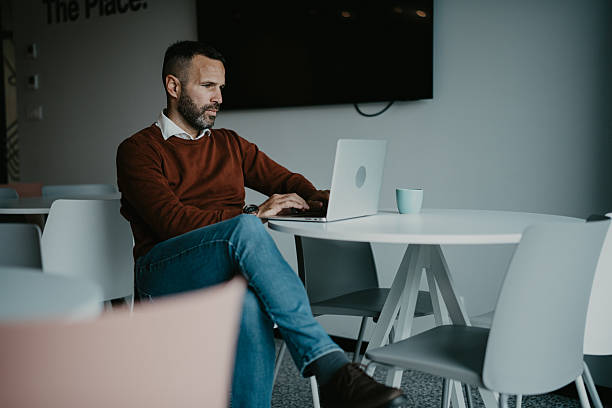 istock Mid adult man working on laptop in modern office 2250653860