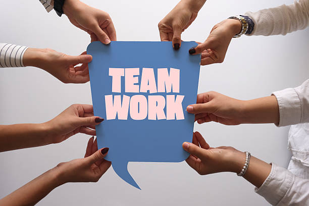Company employees holding speech bubbles that say teamwork