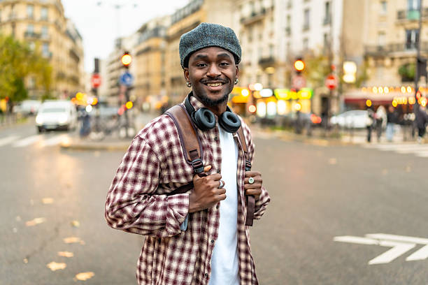istock Smiling young man standing on paris street with backpack 2250657634