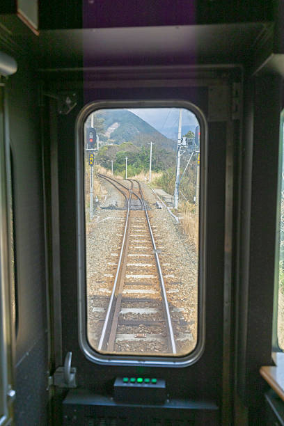 Kumamoto, Japan - March 24, 2025: View through window of vintage lokal train from Kummamoto to Mount Aso Station of Kyushu railway company