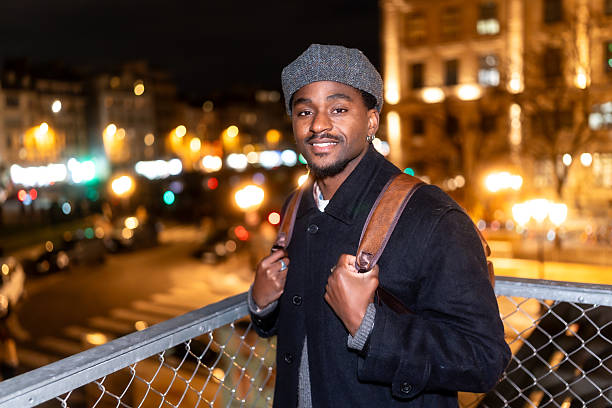 Young black man smiling while traveling in paris at night