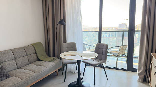 istock Modern cozy living room with soft neutral tones, round dining table and panoramic balcony view 2250659171