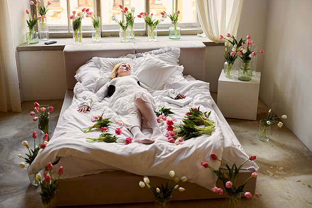 istock Creative scene with scattered petals, Sleeping artist surrounded by blooming tulips and sketches 2250664274