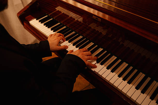 istock Musician playing piano with elegant hands on keys in a warm, inviting atmosphere 2250668013
