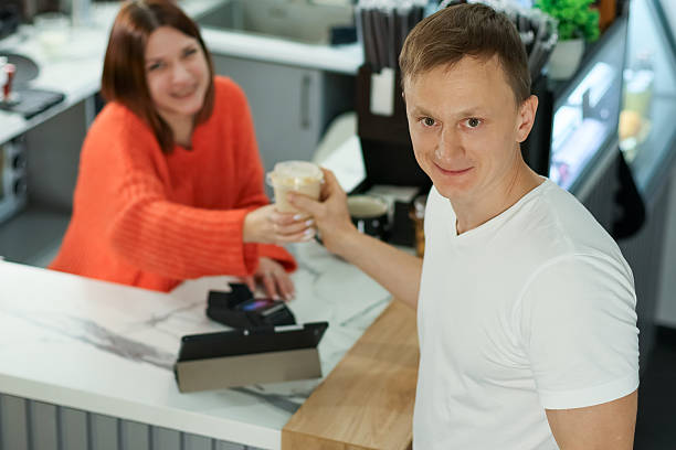 istock Barista and customer toasting with coffee cups at cafe 2250672257
