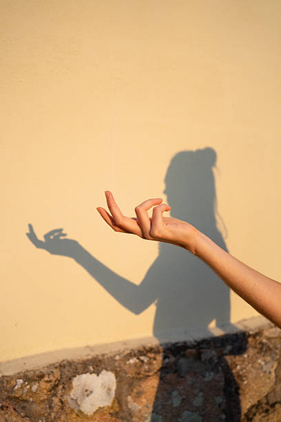 istock Woman hand making mudra gesture with shadow on wall 2250673990