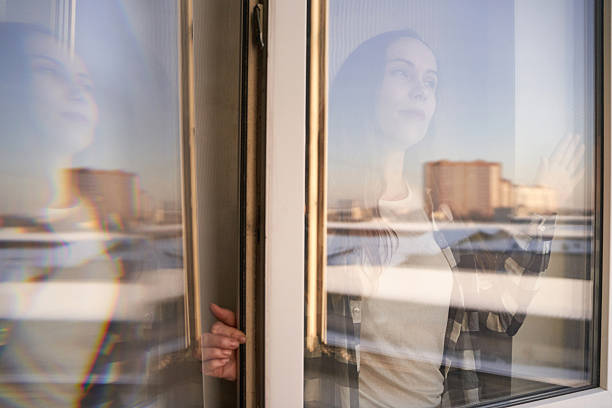istock Young caucasian female gaze through window reflection in urban setting, soft 2250674428