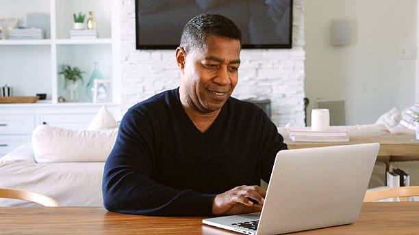 istock Mature Man Sitting At Table At Home Checking Finances On Laptop 2250675111
