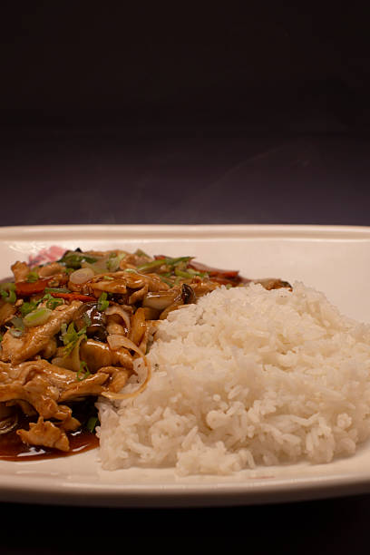 Crispy chicken stirfry accompanied by aromatic rice and fresh