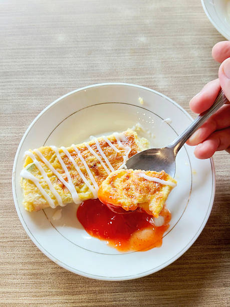 Hand Taking a Bite of Delicious Egg Omelet Roll