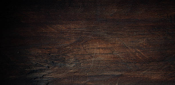 istock A dark rustic wooden surface with visible grain, scratches and natural texture — perfect as a moody background or backdrop. 2250679655