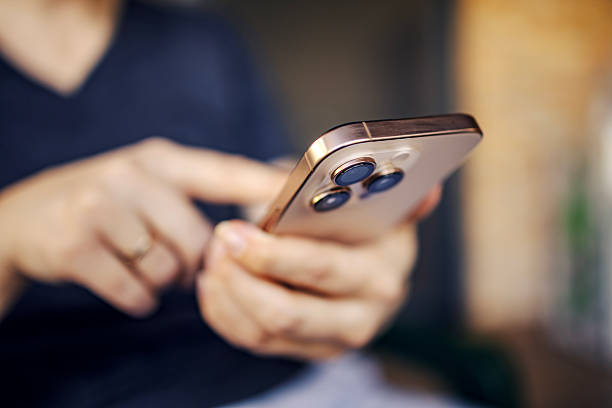 istock Person holding modern smartphone using touchscreen outdoors 2250681117