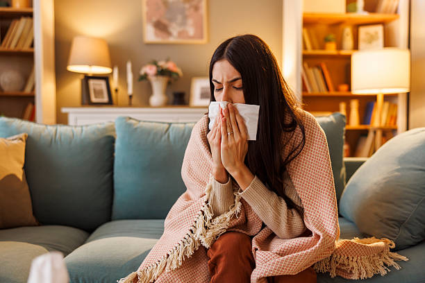 istock Sick woman having flu blowing nose using paper tissues 2250681150