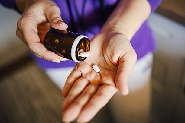 istock Woman pouring pills into her hand from a bottle 2250681543