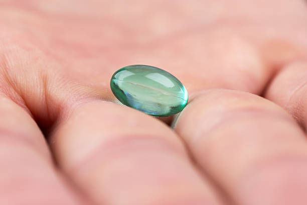 istock Male hand holding one blue capsule pills in hand 2250681886