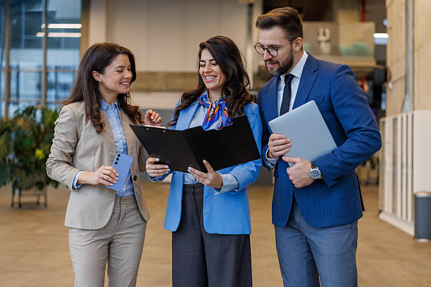 istock Business colleagues collaborating on document in modern office hallway 2250683108
