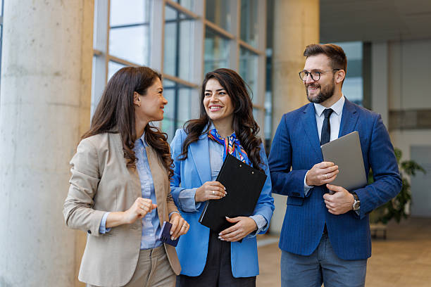 istock Business colleagues walking and discussing in modern office lobby 2250683203