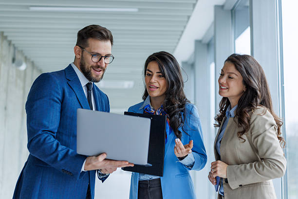 istock Business colleagues collaborating on laptop in modern office hallway 2250683257