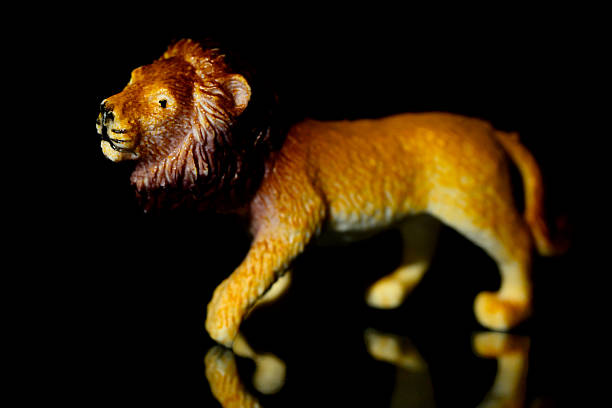 Toy lion on a black glass background