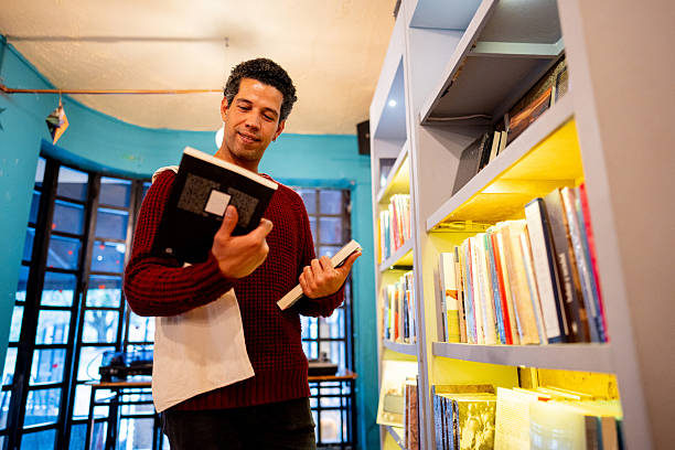 Mid adult man choosing a book at library