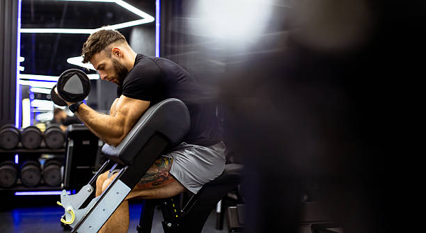 istock Muscular man lifting dumbbell in modern gym during workout session 2250684938