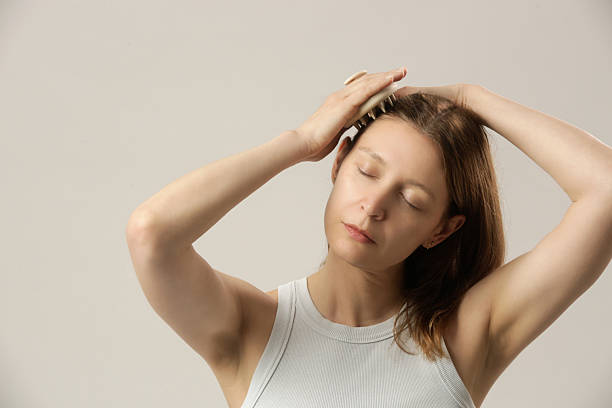 istock Girl doing herself a head massage using a scalp massager, stimulating hair growth, microcirculation, help to distribute natural oils more evenly across the scalp 2250687585