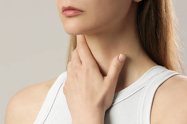 istock Caucasian woman touching her throat. Sore throat, cold, flu, tonsillitis or thyroid gland problem 2250687636