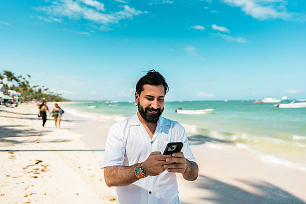 istock Mature man using mobile phone on the beach, Punta Cana 2250687723
