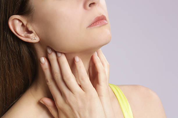Caucasian woman touching her throat. Sore throat, cold, flu, tonsillitis or thyroid gland problem