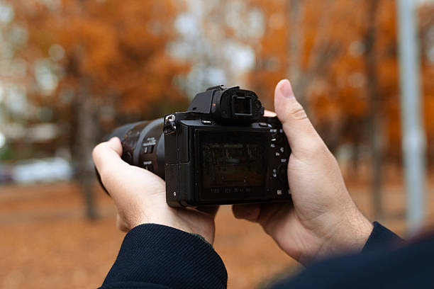 istock Hands Holding Camera with Autumn Background 2250689560