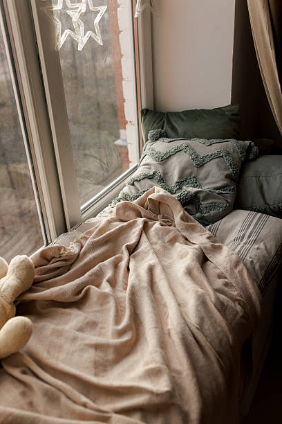 istock Cozy Pillows on Window Seat with Warm Lights 2250689705