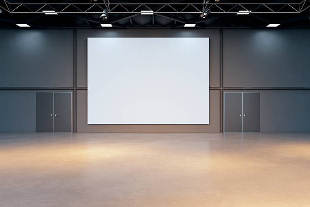 istock Large blank canvas mockup in modern empty indoor showroom with industrial ceiling and spotlights for exhibition or presentation display. 3D Rendering 2250690352