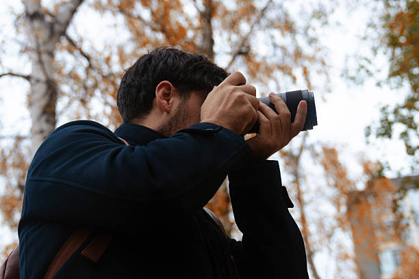 istock Photographer Capturing Autumn Scene in Park 2250690959