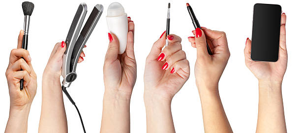 istock Hands holding beauty tools and a smartphone in a creative display for makeup and styling 2250693040