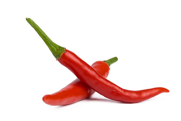 istock Fresh red chili peppers stacked together on a white background for culinary use 2250694275