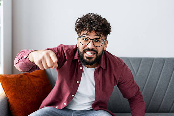 Angry man pointing at camera, shouting with aggressive expression, having an argument