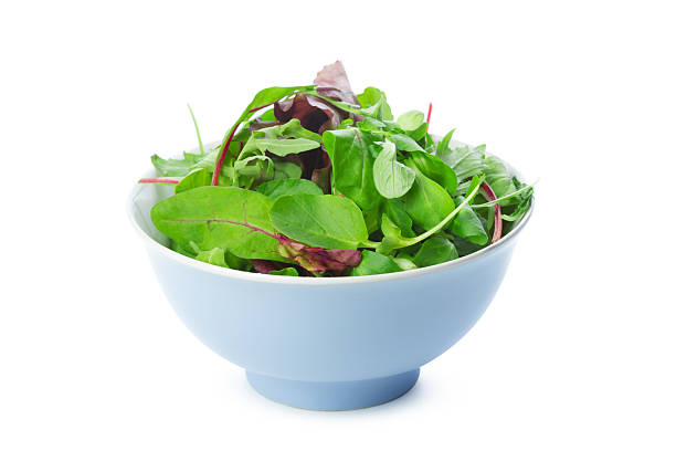 istock Fresh mixed greens salad in a blue bowl on a white background 2250694951