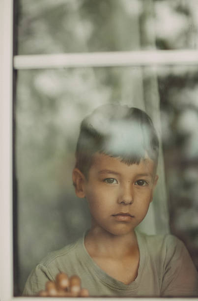 istock Portrait of a boy in a window 2250696158