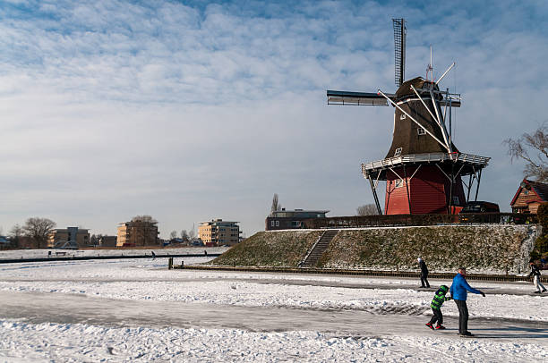 Dokkum, Netherlands - February 5, 2012. Winter scene showing people ice skating on a forzen canal in the city of Dokkum.