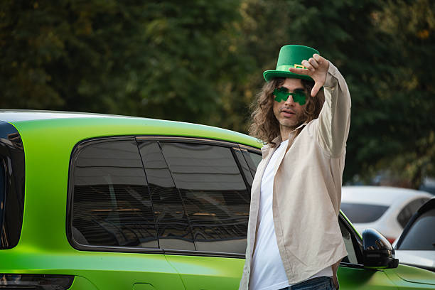 Full length photo of positive funky guy dressed t-shirt shamrock eyewear having fun isolated green color background.