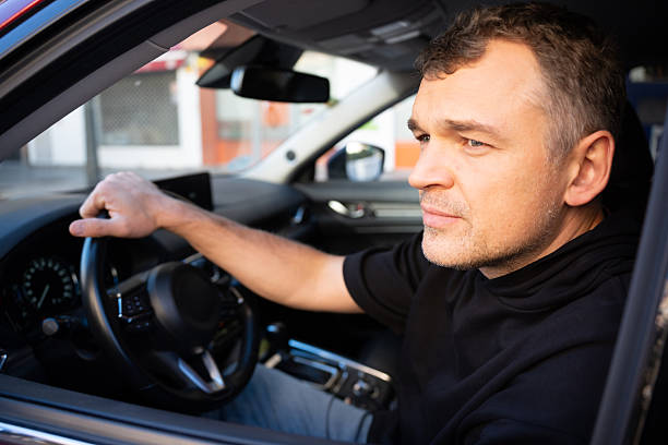 istock Man driving car in city traffic 2250698482