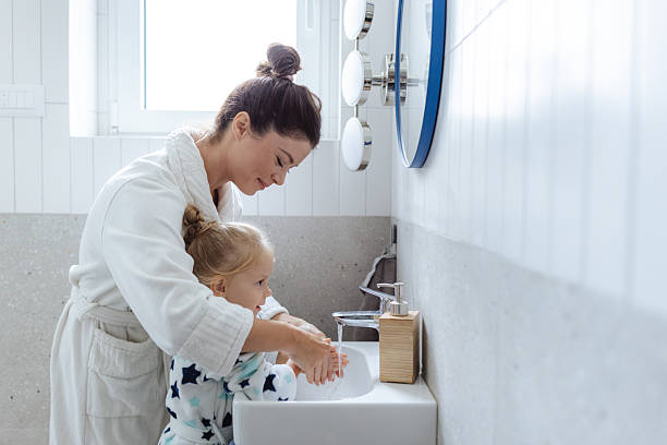 istock Mother helps toddler wash hands in bright bathroom during daily routine 2250702462