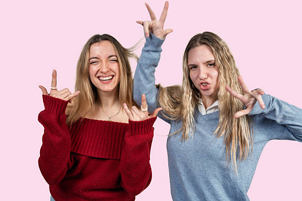 istock Happy young women friends making hand gestures having fun 2250705620
